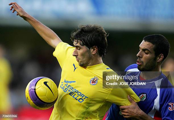 Villarreal's Ruben Cani figths for the ball with Getafe's Italian Fabio Celestini during Spanish league football match at Madrigal Satdium in...