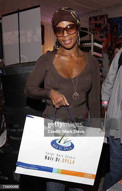 Recording artist Mary J. Blige poses with an Dr. Spela hair bag backstage at the American Music Awards with distinctive assets held at the Shrine...