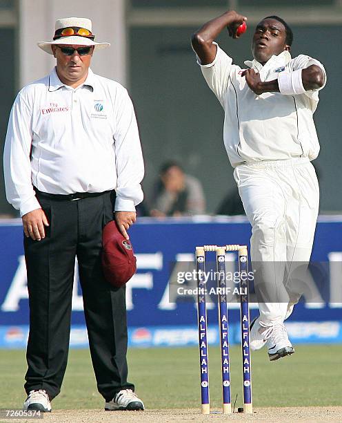 West Indies cricketer Jerome Taylor delivers the ball to Pakistani batsman Umar Gul as field umpire Mark Benson looks on during the second day of the...