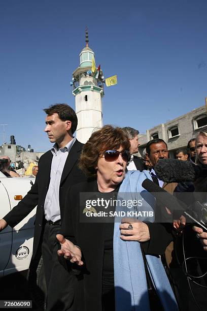 Louise Arbour, the UN high commissioner for human rights, speaks to the press as she walks past the rubble of a destroyed homes and buildings during...