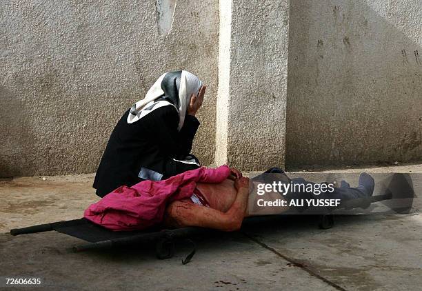 An Iraqi woman weeps nect to the body of her relative outside the morgue of a hospital in the restive city of Baquba northeast of Baghdad, 20...
