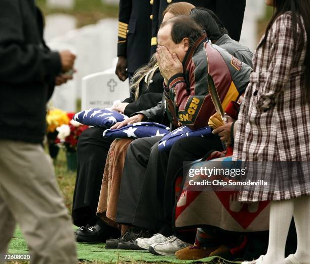 Mervin White wipes his face after receiving a folded flag during the funeral of his son, US Army Staff Sgt. Lucas White, at Arlington National...
