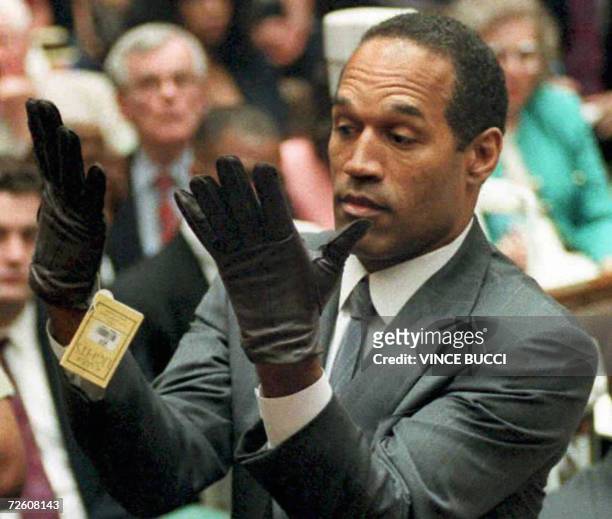 Los Angeles, UNITED STATES: : This 21 June 1995 file photo shows former US football player and actor O.J. Simpson looking at a new pair of Aris...