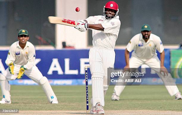 West Indies cricket team captain Brian Lara plays a stroke as Pakistani skipper Inzamam-ul-Haq and his teammate Kamran Akmal look on during the third...