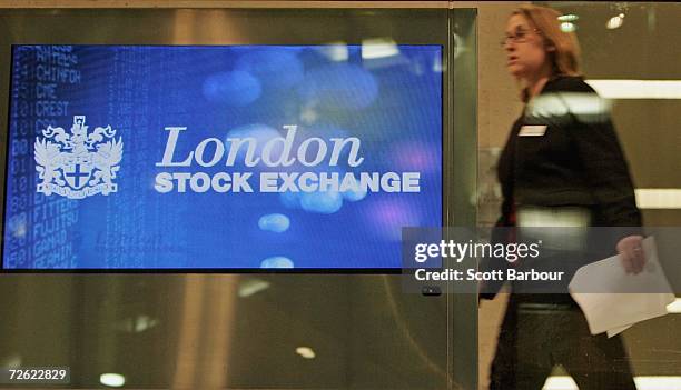 Woman walks past the logo of the London Stock Exchange as it is displayed on a screen in the foyer of the London Stock Exchange on November 22, 2006...