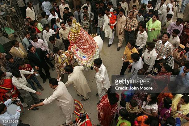 Friends, family and HIV positive Pakistanis watch as Samuel Nazir rides to church in traditional Punjabi costume for his Christan wedding on November...