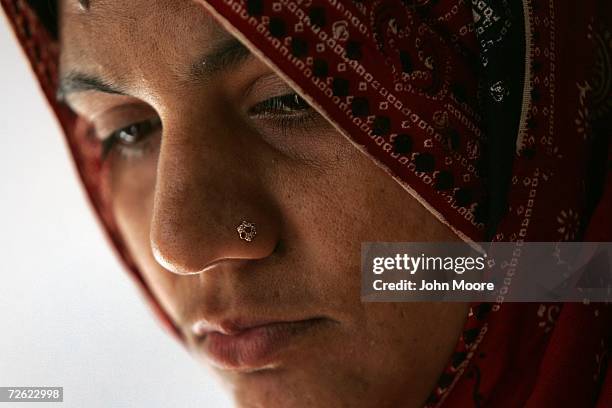 Mother, HIV positive and who preferred not to be identified, awaits a month's supply of AIDS fighting anti-retroviral drugs at a distribution center...