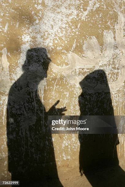 Saeed Khan, age 40 and HIV positive, speaks with one of his two wives, ages 32 and 16, both with HIV, in the courtyard of their village home on...