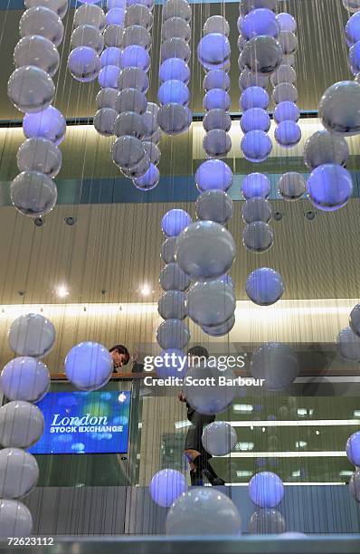 People walk past the specially commissioned sculpture called 'The Source', by artists Greyworld in the atrium at the London Stock Exchange on...