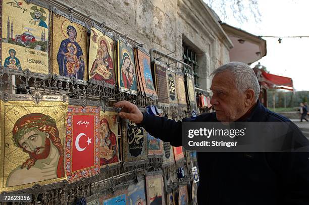 Turkish man browses through Christian souvenirs in front of the Haghia Sophia in the old city on November 16, 2006 in Istanbul, Turkey.. Pope...