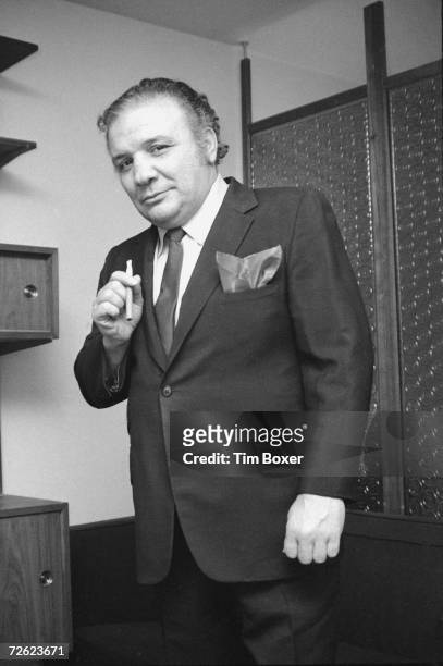 Portrait of American middleweight boxing legend Jake LaMotta as he stands and holds a cigar, 1970.
