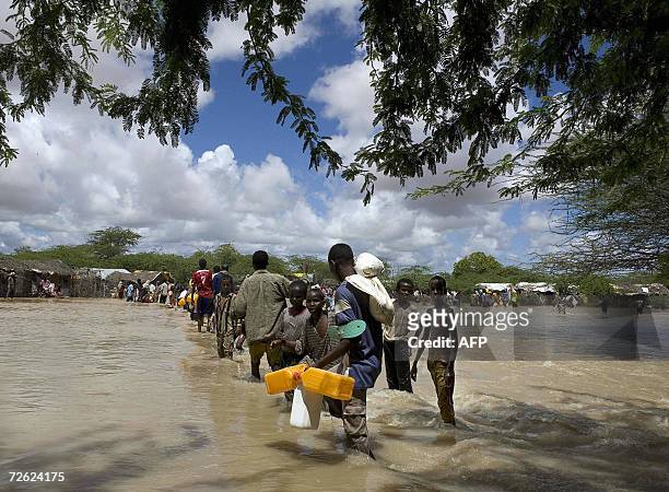 Somali refugees displaced by floods cross a swollen river in Dadaab, Garissa district in Kenya's arid northeastern province 22, November 2006. Barely...