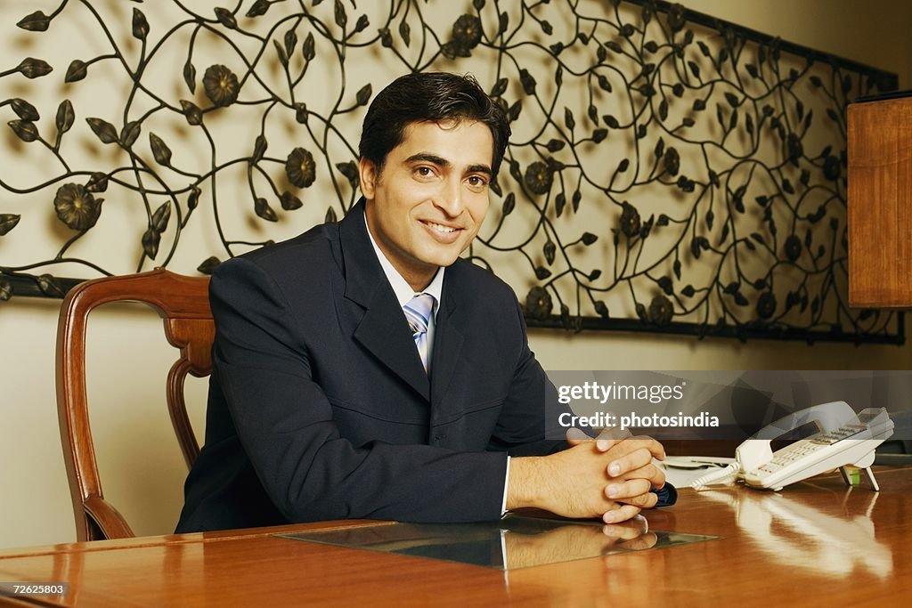 Portrait of a businessman smiling with his hands clasped