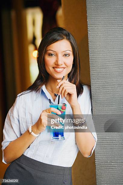 portrait of a young woman holding a glass of cocktail - rietje los stockfoto's en -beelden