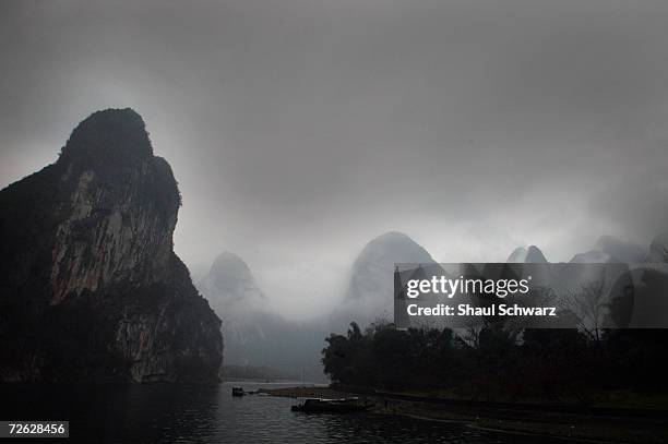 Dark clouds cover the landscape of towering karst formations surrounding the Li River on February 09, 2004 in the south of China. Notorious for its...