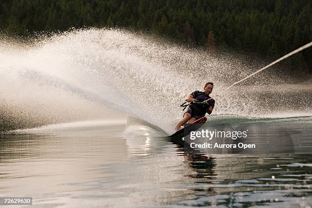 young man waterskiing on lake koocanusa in the east kootenays near fernie, british columbia, canada. - waterskiing - fotografias e filmes do acervo