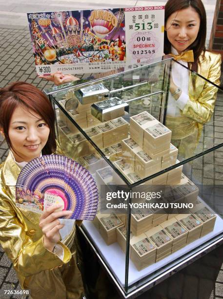 Campaign girls Eri Nishiyama and Juri Toyama show off lottery tickets of the 300 million yen Year-End Jumbo Lottery while 300 million yen bank notes...