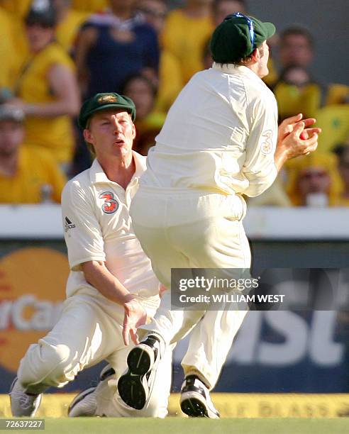 Australian fieldsman Mike Hussey catches England batsman Andrew Strauss but injures fellow fieldsman Brett Lee on the second day of the first Ashes...