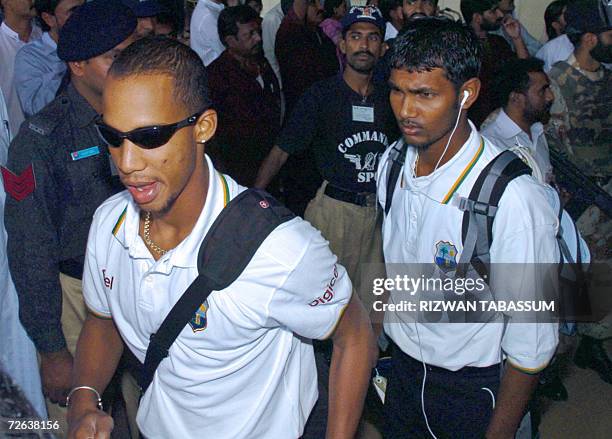 West Indian cricketers Dwayne Bravo and Denesh Ramdin walk past security personnel upon their arrival at Jinnah Terminal in Karachi, 24 November...