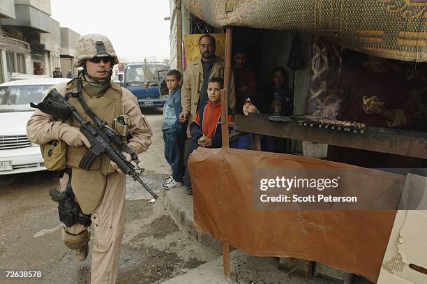 Marine of the 4th Civil Affairs Group passes a kebab stand as they visit hospitals, a mosque and other locations in Fallujah to discuss US-funded...