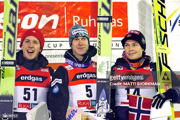 Finland's Arttu Lappi celebrates on the podium with Switzerland's Simon Amman and Norway's Anders Jacobsen after winning the season's first Ski...
