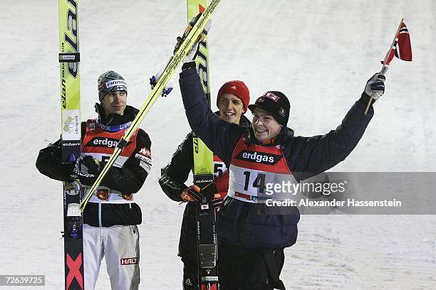 Anders Jacobsen of Norway celebrates winning the third place at the first Ski-jumping event of the season, whilst winner Arttu Lappi of Finnland and...