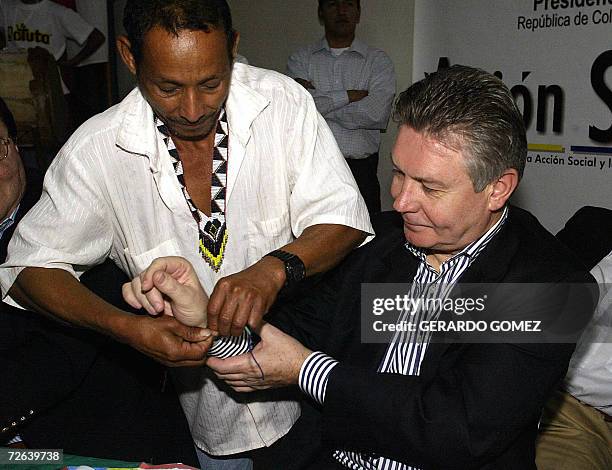 Belgium Foreign Minister Karel de Gucht receives a bracelet from Eduardo Barrios Atencio, a local indigenous, during his visit to Comuna 13 in...