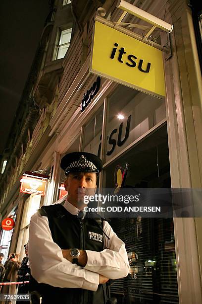 London, UNITED KINGDOM: British police guards the entrance to Itsu restaurant in London's Piccadilly, 24 November 2006. Former spy Alexander...