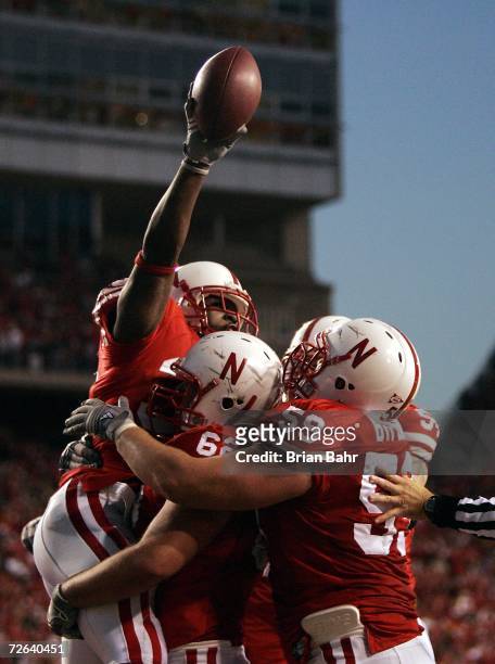 Brandon Jackson of the Nebraska Cornhuskers celebrates his touchdown catch with Andy Christensen and Brett Byford against the Colorado Buffaloes in...
