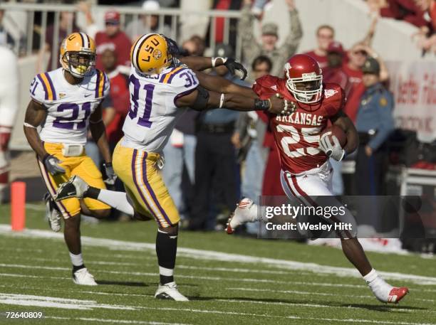 Felix Jones of the Arkansas Razorbacks stiff arms Jessie Daniels of the LSU Tigers during a run at War Memorial Stadium on November 24, 2006 in...