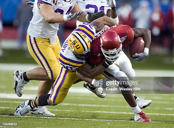 Darren McFadden of the Arkansas Razorbacks is tackled by LaRon Landry of the LSU Tigers at War Memorial Stadium on November 24, 2006 in Little Rock,...