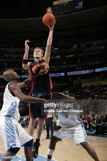 Andris Biedrins of the Golden State Warriors goes to the basket against Joe Smith of the Denver Nuggets on November 24, 2006 at the Pepsi Center in...