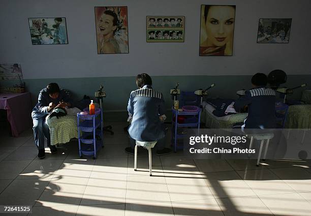 Inmates practice facial treatment during a beauty training session at the Jilin Women's Prison on November 24, 2006 in Changchun of Jilin Province,...