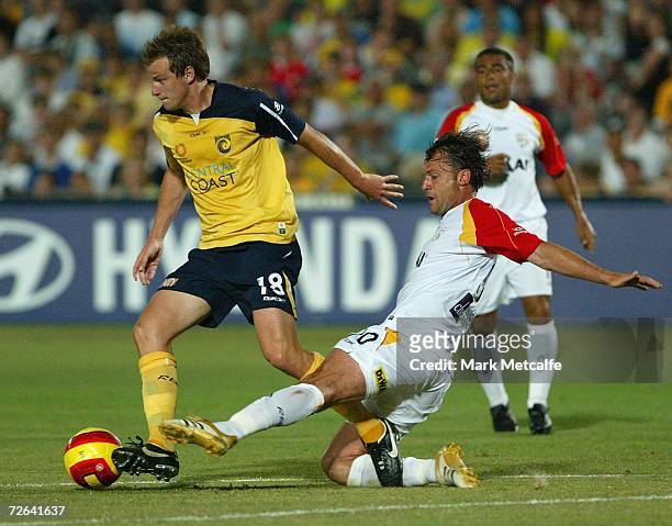 Alex Wilkinson of the Mariners is tackled by Fernando of Adelaide during the round fourteen Hyundai A-League match between the Central Coast Mariners...