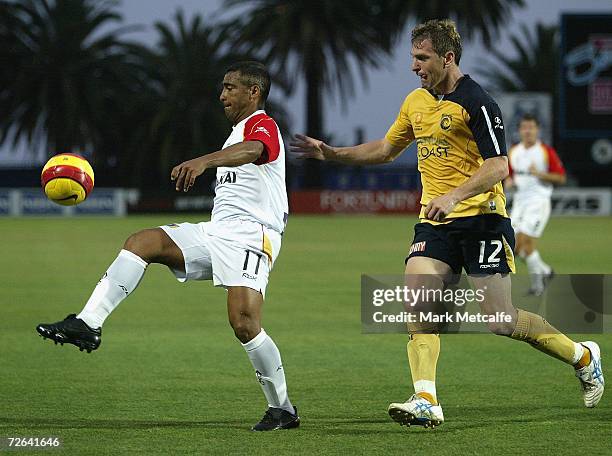 Romario of Adelaide is challenged by Stewart Petrie of the Mariners during the round fourteen Hyundai A-League match between the Central Coast...