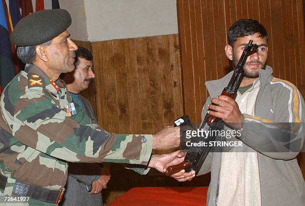 Kashmiri Muslim militant surrenders his weapon to an Indian army officer during a surrender ceremony at Baramulla, some 55 kms north of Srinagar, 25...