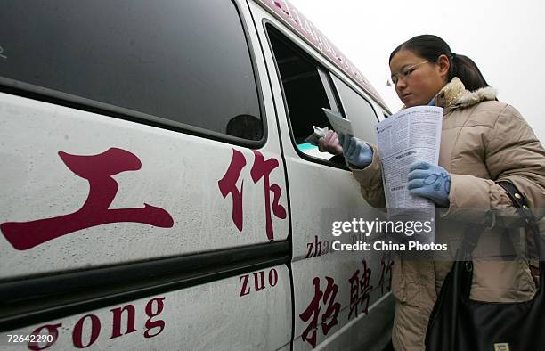 Job applicant buys admission ticket of a job fair for recruitment of positions in departments under the State Council, at the Beijing Agricultural...