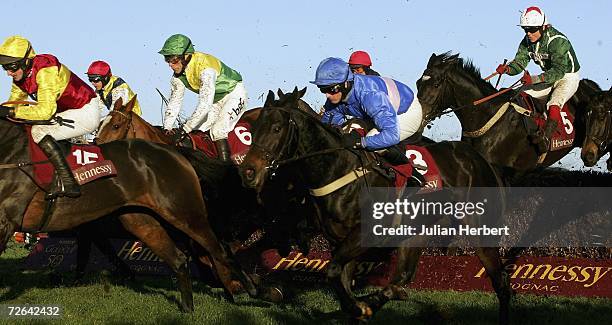 Paul Moloney and State of Play clear the 10th fence before landing The Hennessy Cognac Gold Cup Steeple Chase Race run at Newbury Racecourse on...