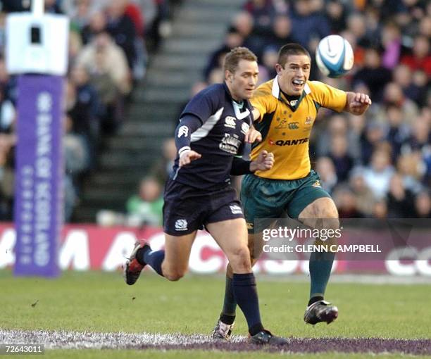 Edinburgh, UNITED KINGDOM: Australian fullback Chris Latham chases after the loose ball followed by an unidentified Australian player as Australia...