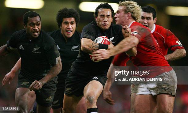 Cardiff, UNITED KINGDOM: New Zealands' winger Rico Gear is tackled by Wales' Alix Popham during the Autumn international rugby union test match at...