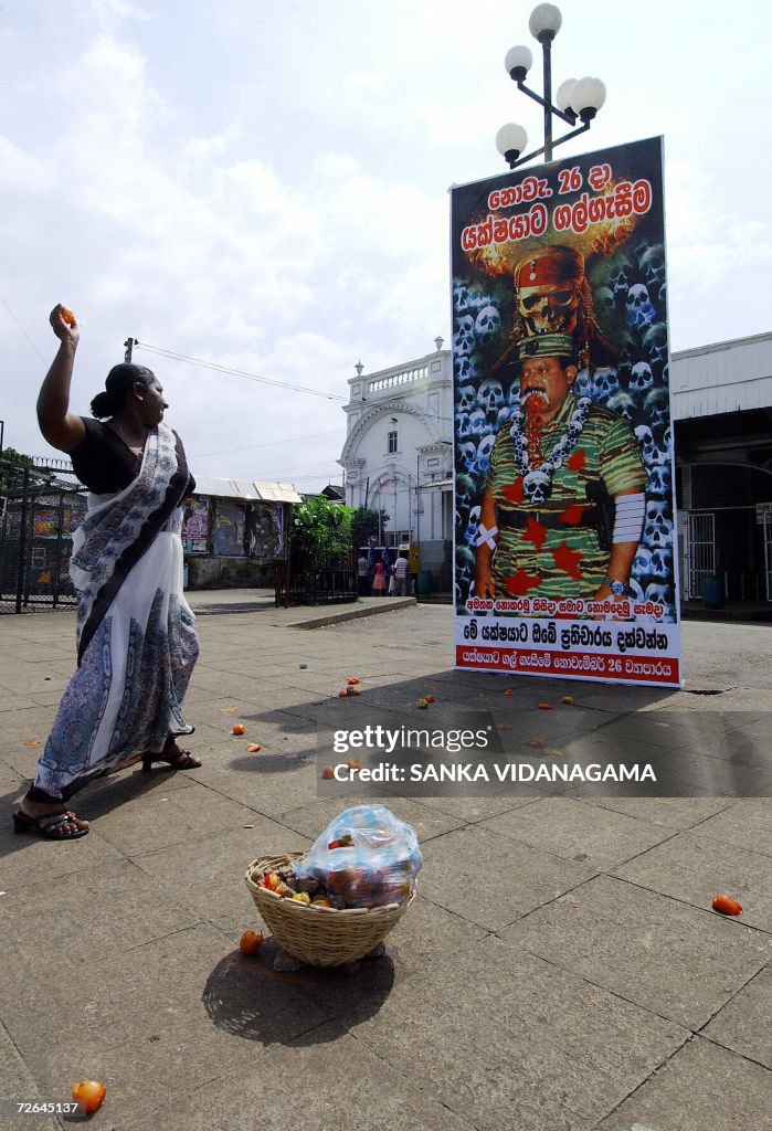 A Sri Lankan woman throws a tomato towar