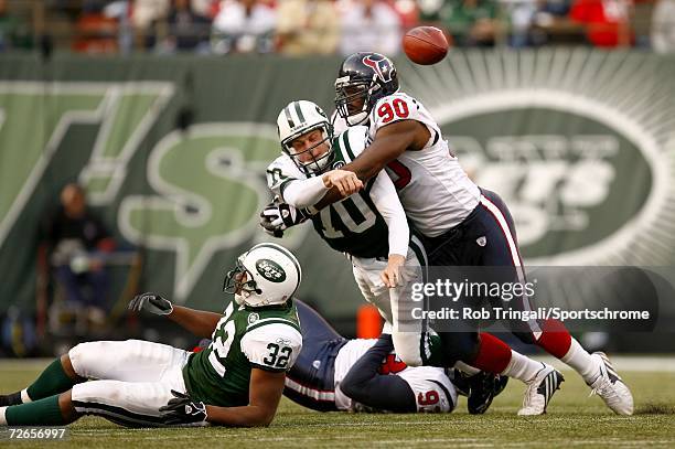 Quarterback Chad Pennington of the New York Jets tries to complete a pass while being pressured by Mario Williams of the Houston Texans at Giants...