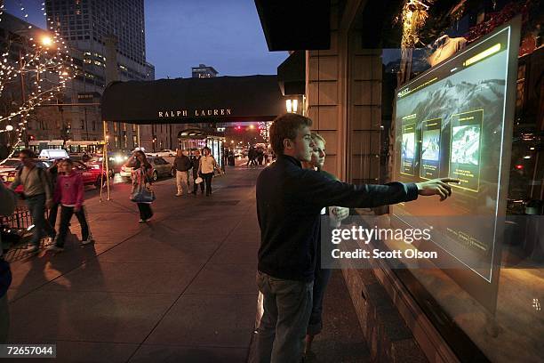 Drew Johnson and Mack Sawicki, both from Kansas City, try "cyber shopping" with an interactive window display outside the Ralph Lauren store along...