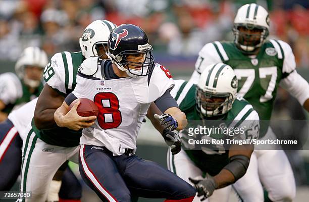 Quarterback David Carr of the Houston Texans is pressured by Bryan Thomas and Dewayne Robertson of the New York Jets at Giants Stadium on November...
