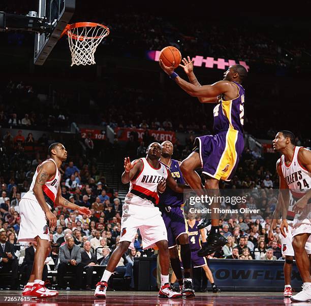 Kobe Bryant of the Los Angeles Lakers drives to the basket for a layup against Zach Randolph and Stephen Graham of the Portland Trail Blazers during...