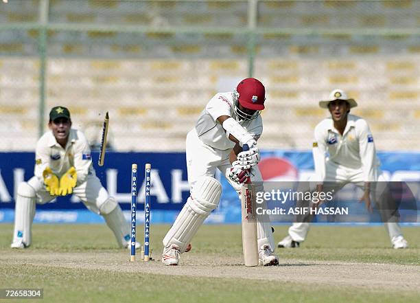 Pakistani wicketkeeper Kamran Akmal tries to catch a wicket after West Indies captain Brian Lara is bowled out by unseen Pakistani bowler Umar Gul...