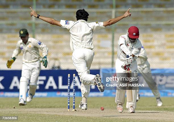 Pakistani bowler Umar Gul celebrates the wicket of West Indies captain Brian Lara as wicketkeeper Kamran Akmal looks on during the second day of the...