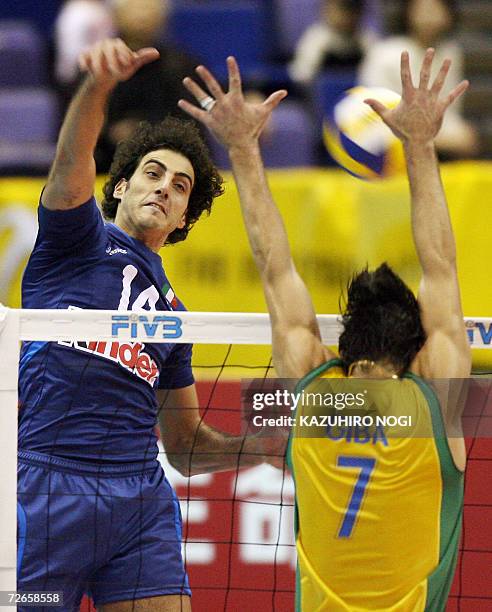 Italian Alessandro Fei spikes the ball against Brazilian blocker Gilberto Godoy Filho during their Pool F second round match at the Men's World...