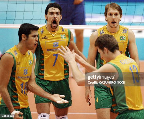 Brazilian Gilberto Godoy Filho 'GIBA' and teammates cheer up each other during their Pool F second round match against Italy at the Men's World...