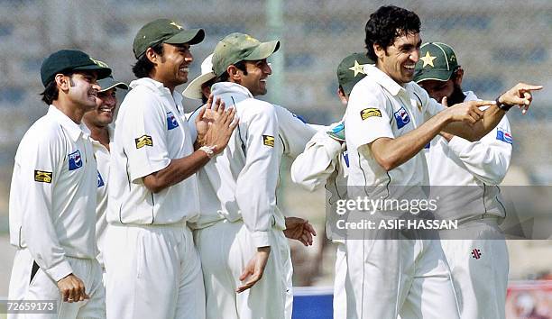 Pakistani bowler Umar Gul gestures as he celebrates with his teammates after taking the wicket of West Indies cricketer Ramnaresh Sarwan during the...